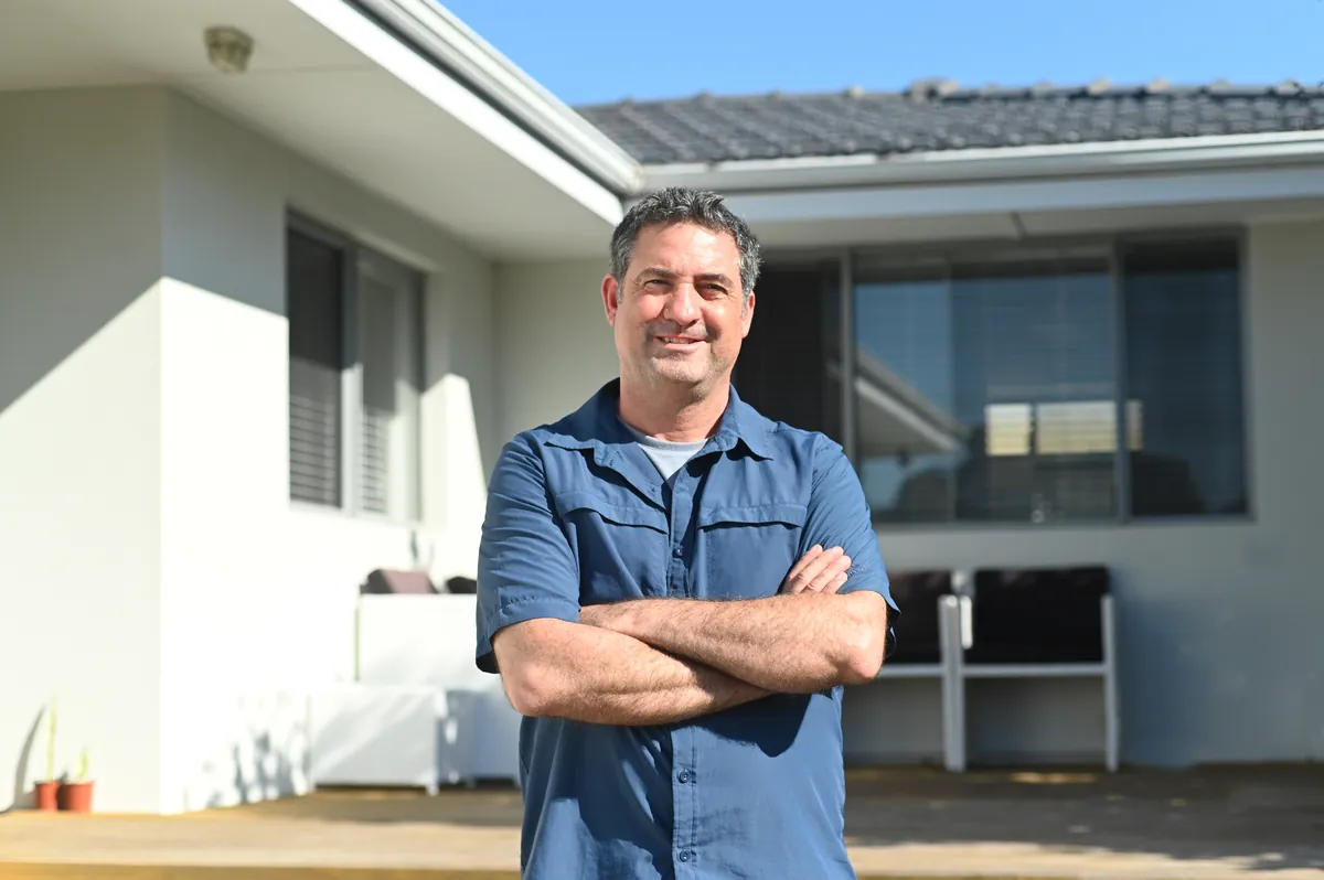 Homeowner standing in front of his house