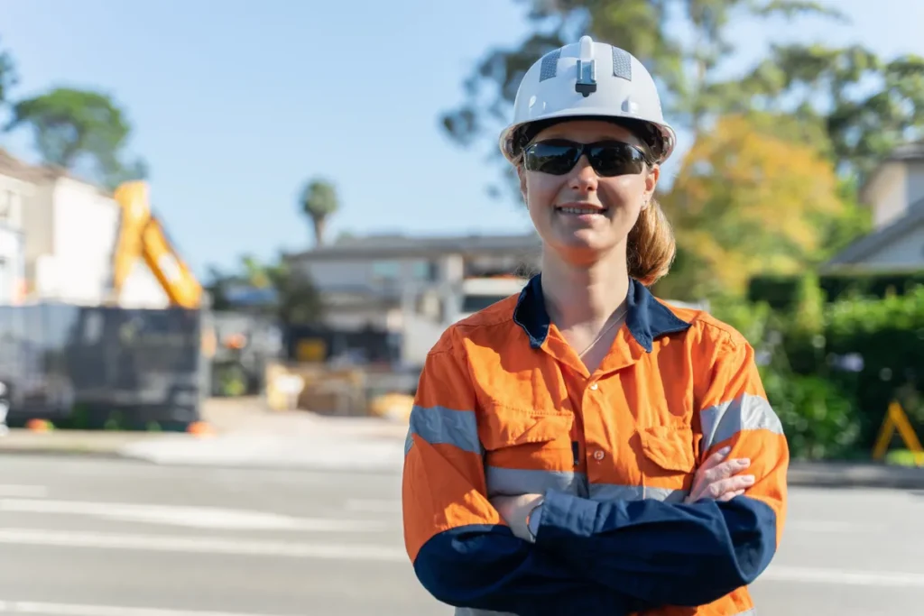 Self-employed tradie in hi-vis workwear standing on a residential street
