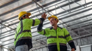 Two tradies in hi-vis workwear discussing a job on a construction site